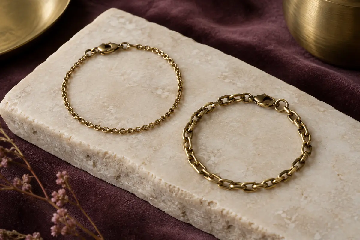 Bracelets chaîne fins et à maillons présentés sur une plaque de pierre crème