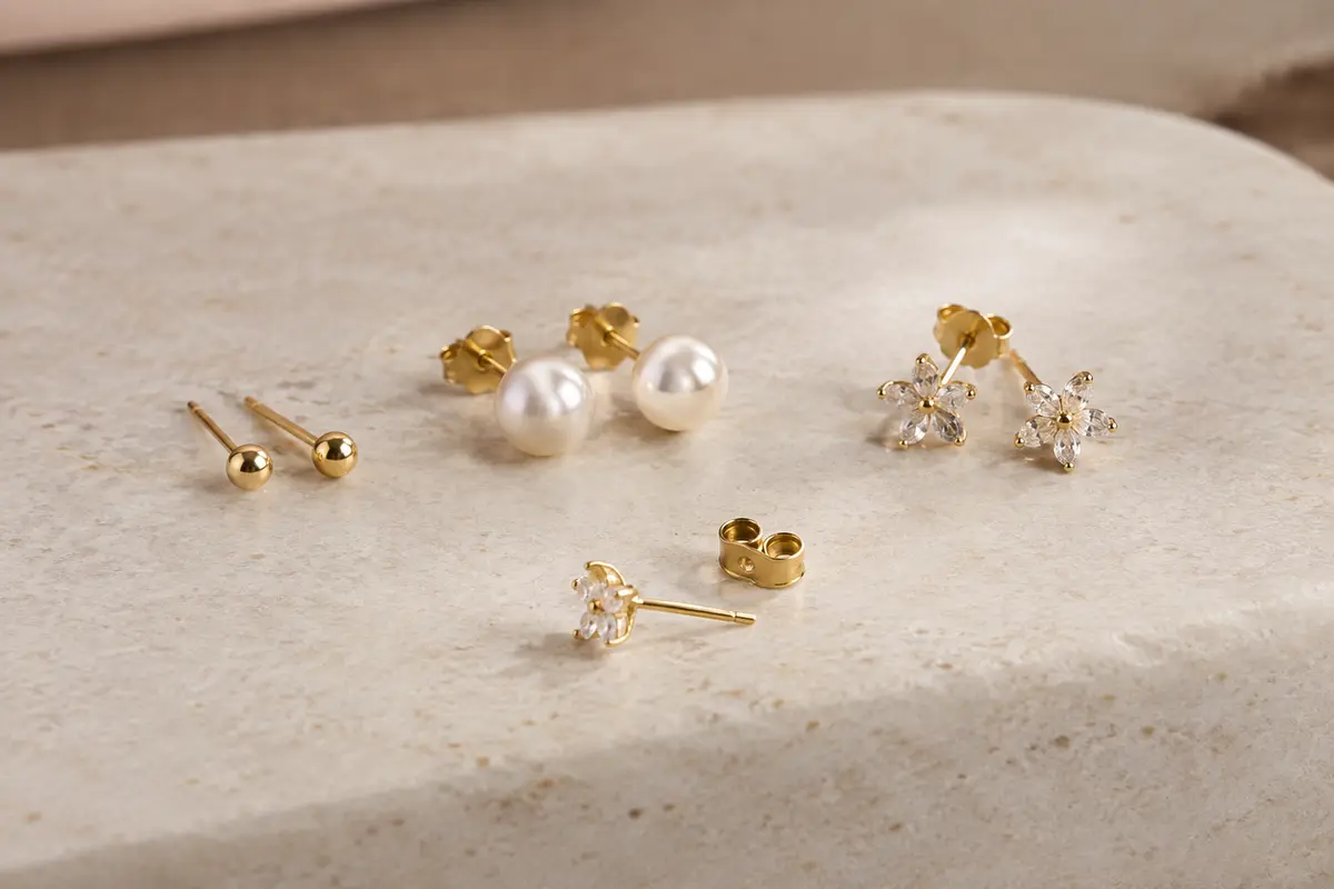 Puces d’oreilles de tailles et de styles variés présentées avec leurs fermoirs sur un fond neutre.