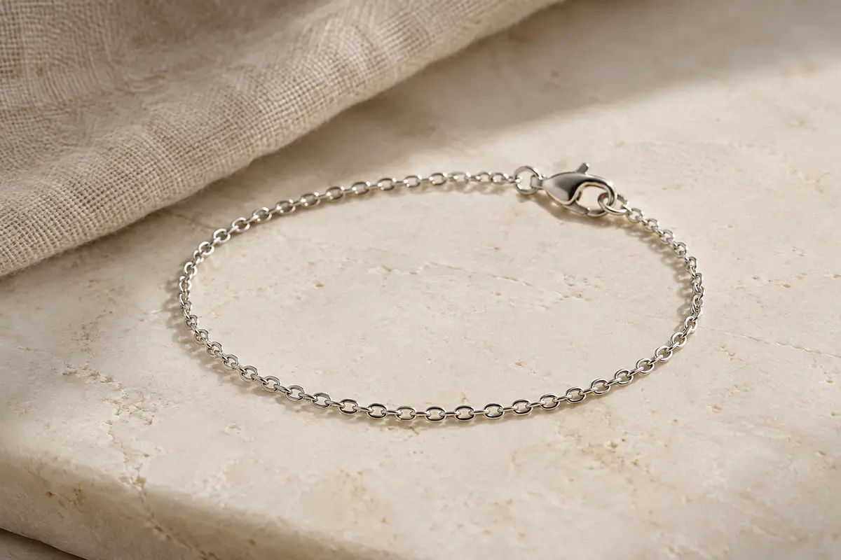 Bracelet chaîne Amberta en argent 925 posé en courbe sur une surface minérale claire.