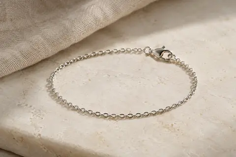 Bracelet chaîne Amberta en argent 925 posé en courbe sur une surface minérale claire.