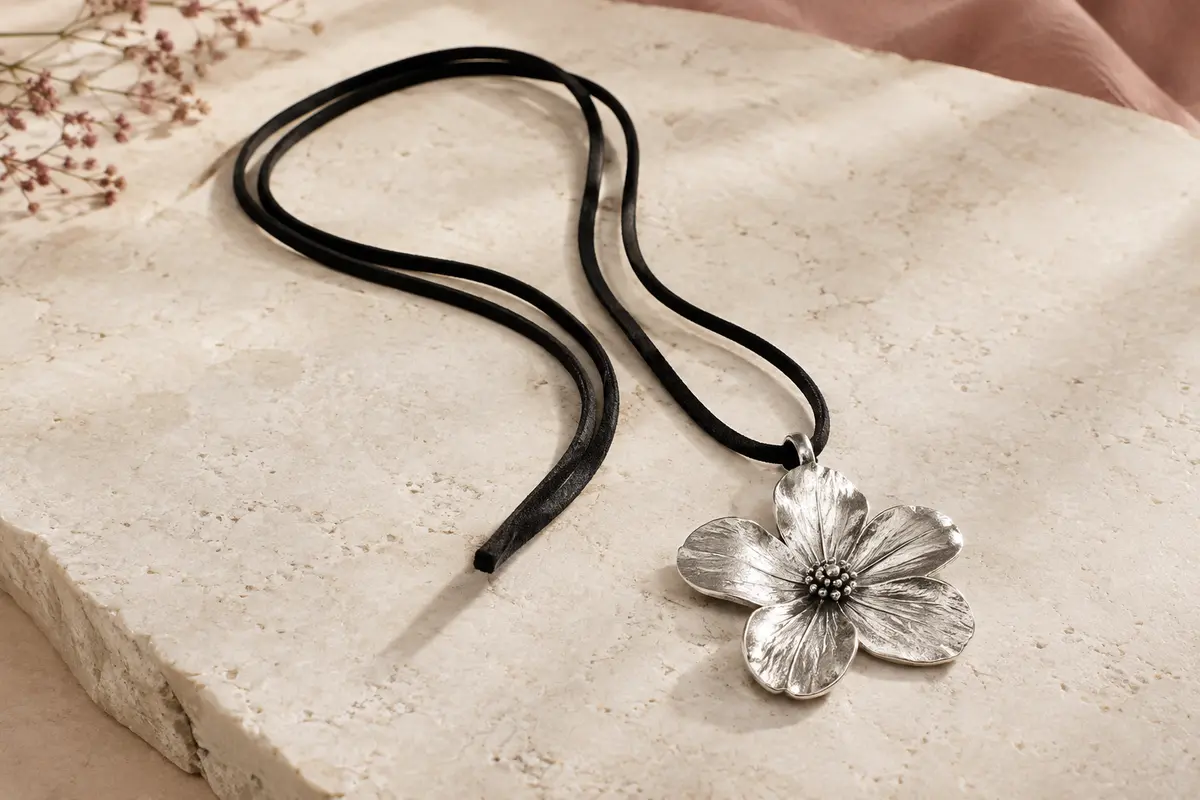 Collier long à cordon noir en suédine et grand pendentif fleur à finition argentée