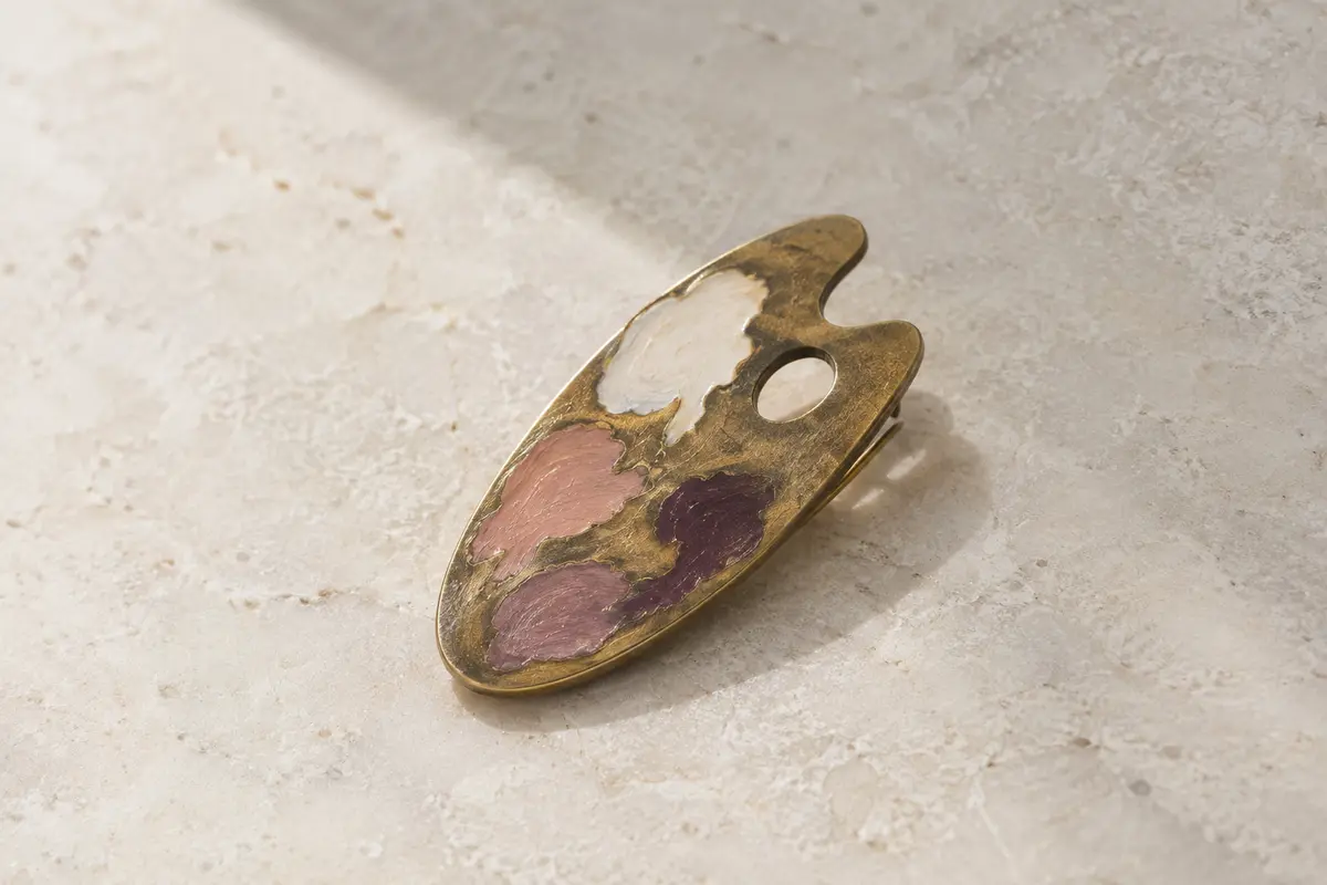 Broche en forme de palette de peintre, en laiton vieilli avec un décor émaillé peint à la main.