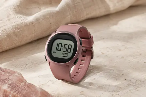 Montre digitale de sport avec écran numérique et bracelet en silicone, présentée seule sur une surface minérale claire.