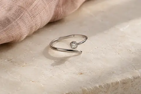 Bague fine en spirale de ton argenté, ornée d’un oxyde de zirconium sur une surface claire