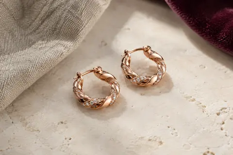 Paire de créoles torsadées HEEYA en argent 925 à finition rose doré et pierres en zirconium cubique.