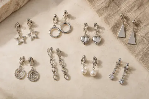 Dix paires de boucles pendantes à clips argentées, aux formes et détails décoratifs variés.