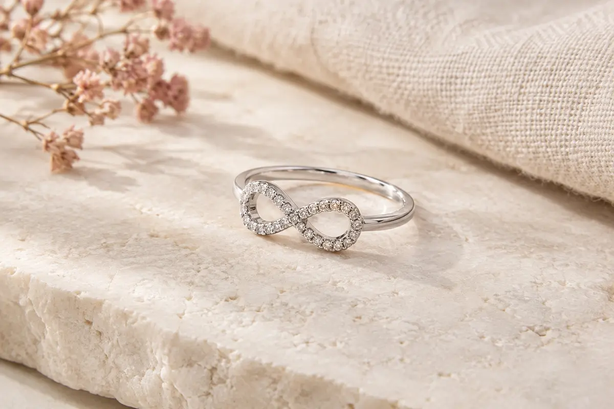 Bague en argent au motif infini serti de zircons cubiques, présentée sur une surface claire.