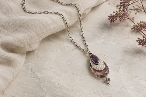 Collier long Mecool à chaîne C-link et pendentif à triple couche posé sur du lin naturel