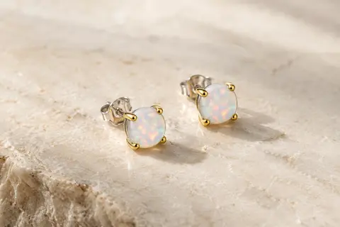 Paire de puces d’oreilles à opale irisée de 5 mm sur une monture en argent aux finitions plaquées.