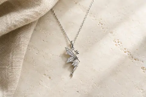 Sautoir long en argent avec pendentif fée orné de zircons cubiques sur une surface claire