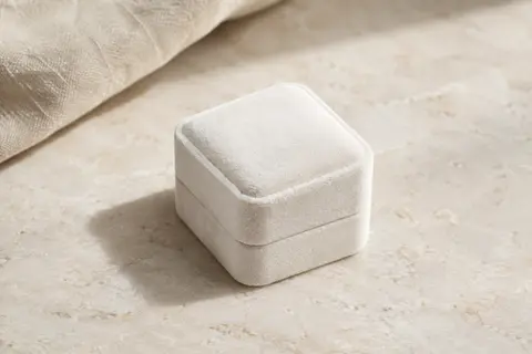 Écrin carré Oirlv en velours blanc, présenté seul sur une surface minérale claire.