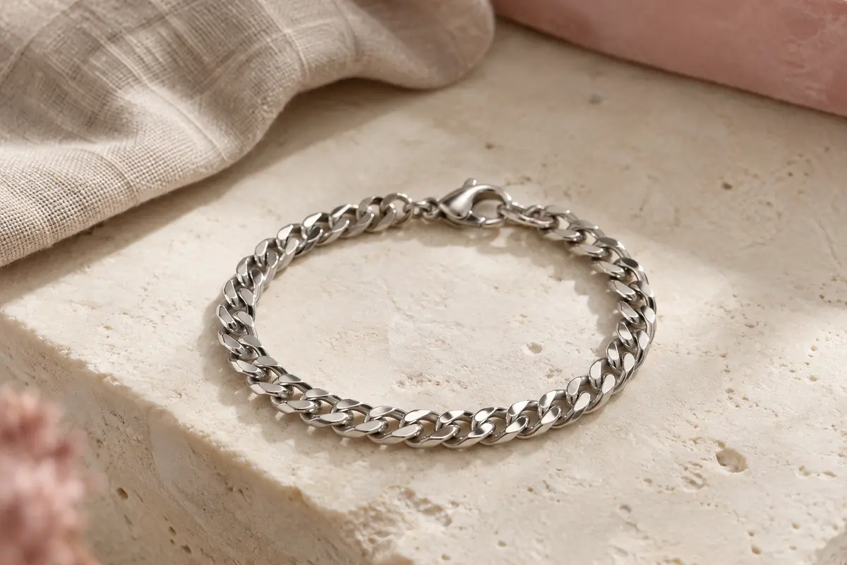 Bracelet gourmette PROSTEEL à maille cubaine argentée présenté seul sur une surface minérale claire.
